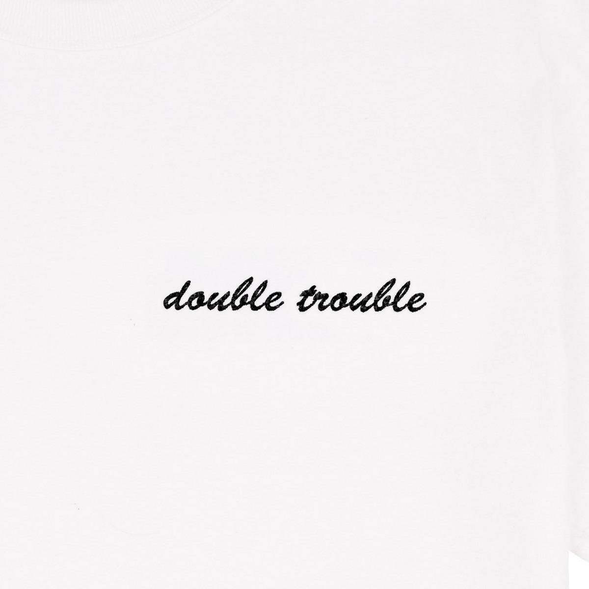 "double trouble" embroidered in noir thread on a white tee: front-on close-up