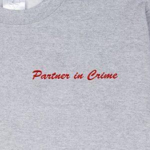"Partner in Crime" embroidered in crimson-cherry thread on a grey sweatshirt: front-on close-up