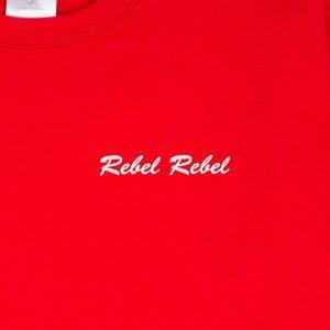 "Rebel Rebel" embroidered in blanc thread on a red sweatshirt: front-on close-up