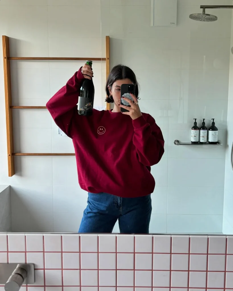Burgundy sweatshirt with a small cream smiley on the chest